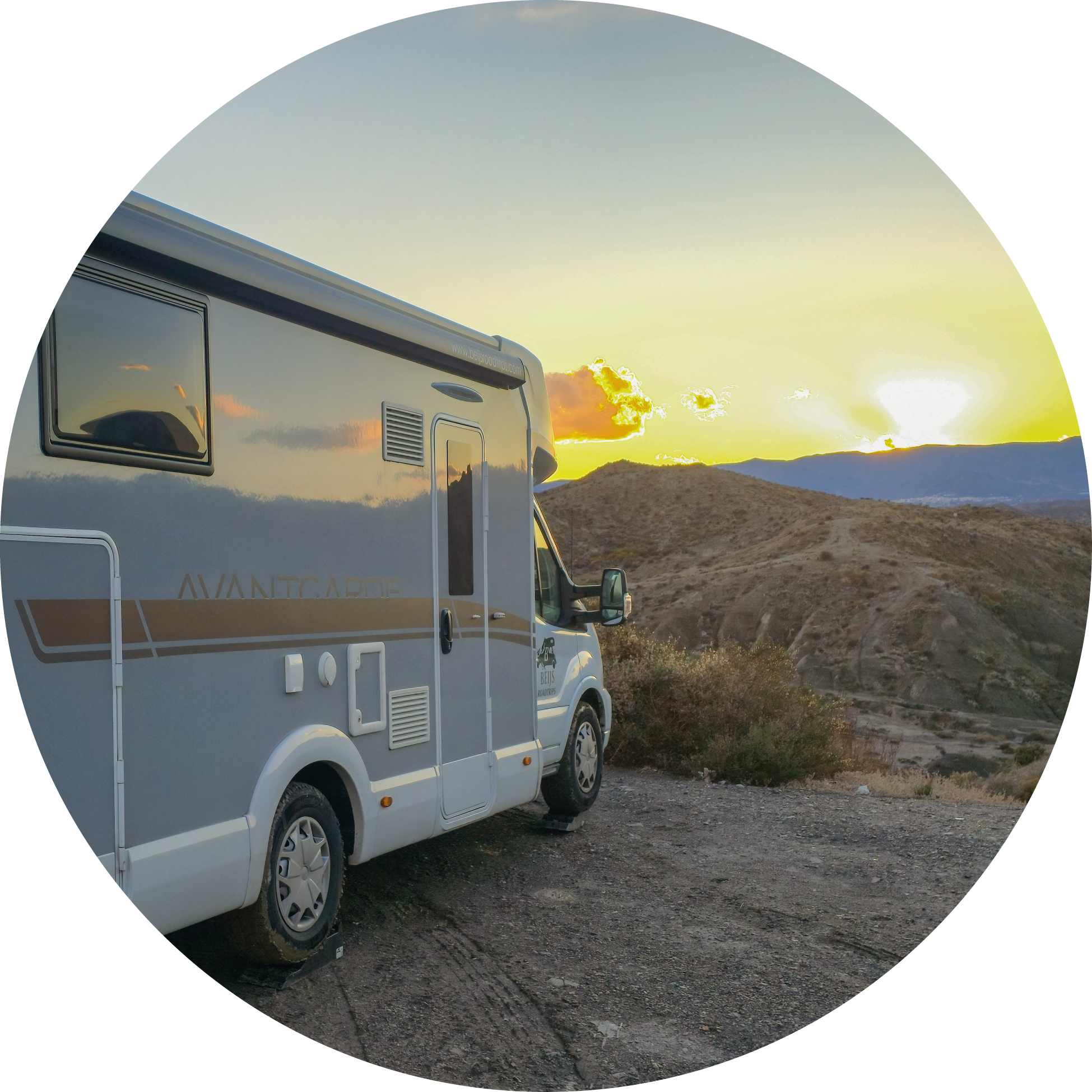 The semi-integrated motorhome from Beijs Roadtrips Motorhome Rental photographed from the side overlooking the sunset in the desert in Southern Spain